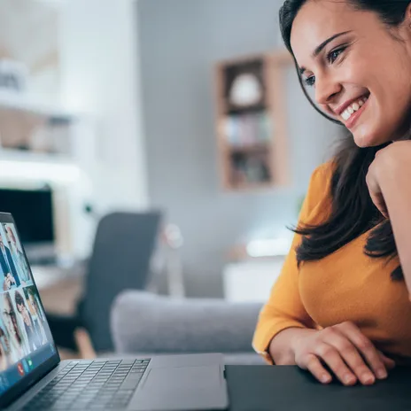 Smiling woman participating in a virtual class to learn Romanian online through group video call
