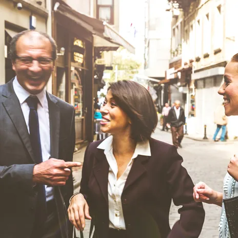 Business professionals laughing and interacting outdoors, illustrating positive outcomes of corporate culture training