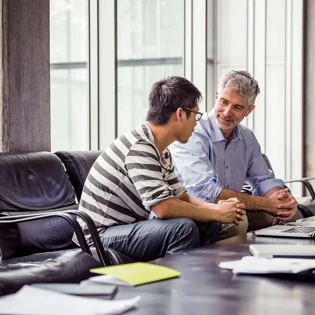 Professional language instructor mentoring an adult student in a one-on-one session, highlighting personalized learning available through Berlitz.com.

